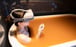 An employee of Arima Onsen tries out the new virtual reality experience while posing in a bathtub filled with water from a hot spring. Photo: Handout