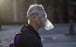 A man uses a plastic bottle as a face mask as he walks along a seafront promenade in Barcelona, Spain. Photo: AP