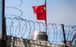The Chinese flag behind barbed wire at Beijing’s San Francisco consulate. Photo: AFP