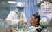 A nurse in a protective suit feeds a coronavirus patient in an isolated ward in Wuhan. Photo: Reuters