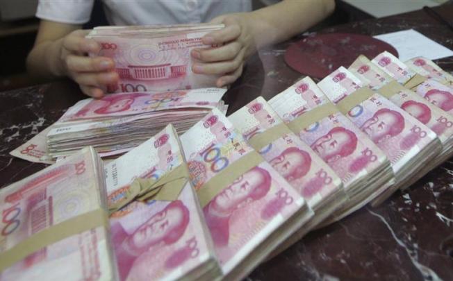 An employee counts Chinese 100 yuan banknotes at a branch of Bank of Communications in Shenyang, Liaoning province July 6, 2012. REUTERS/Stringer
