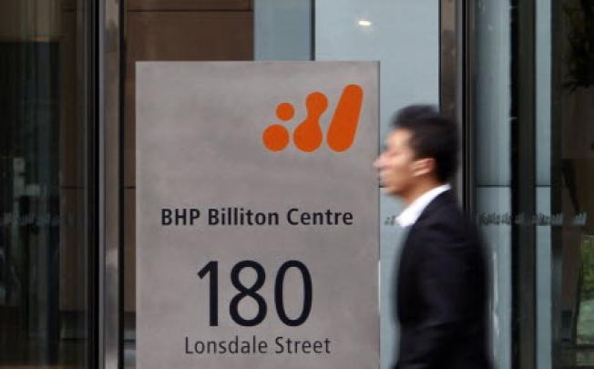 File photo of a man walking past the head office of BHP Billiton in central Melbourne. MICK TSIKAS/REUTERS 