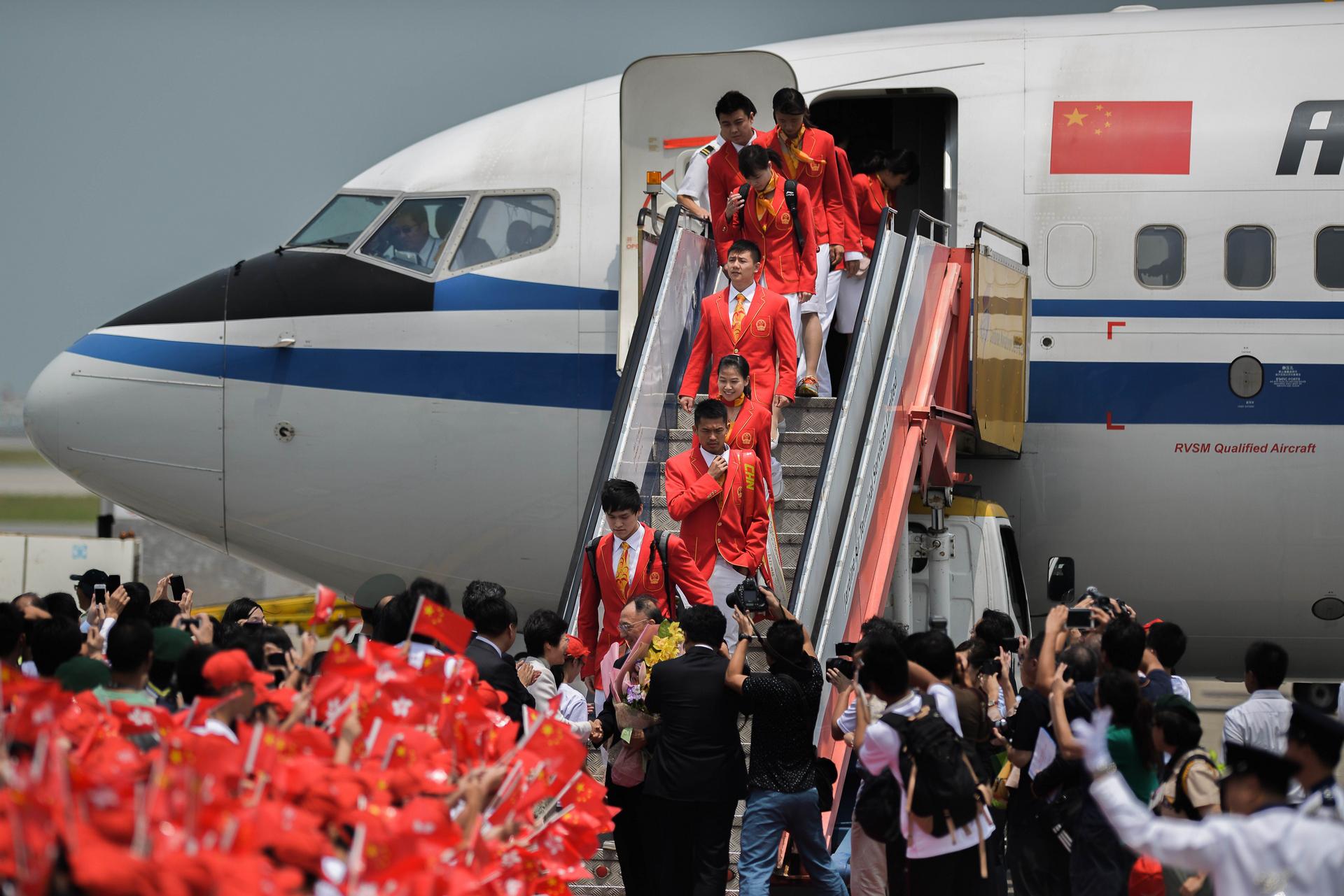 China's gold medallists arriving at Chek Lap Kok. Photo: AFP