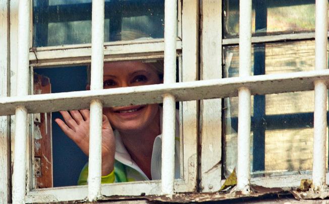 Jailed former Ukrainian Prime Minister Yulia Tymoshenko waves to supporters from a prison window in Kiev, Ukraine. Photo: AP