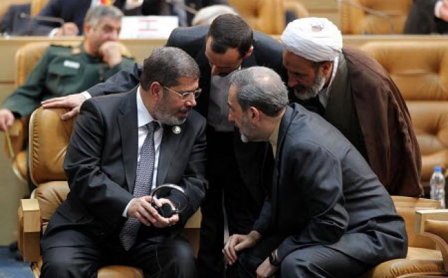 Egyptian President Muhammed Mursi talks with Iranian officials at the Non-Aligned Movement summit in Tehran. Photo: AP
