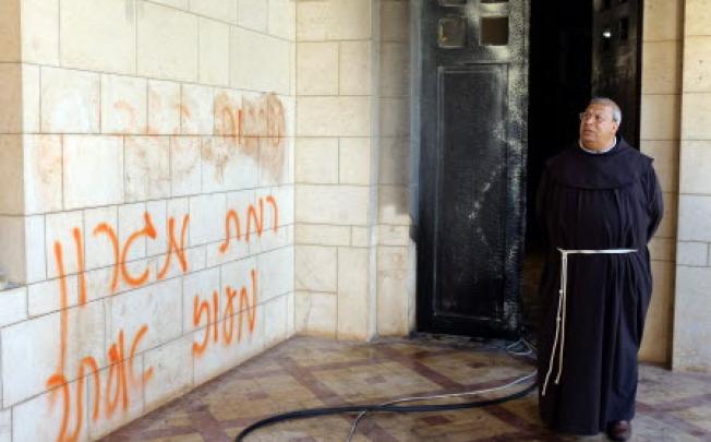 Abdel Maseru, a Franciscan monk from Jaffa visits the Trappist Monastery at Latroun, Israel, on Tuesday, where graffiti was spray painted and a door set ablaze. Photo: EPA  