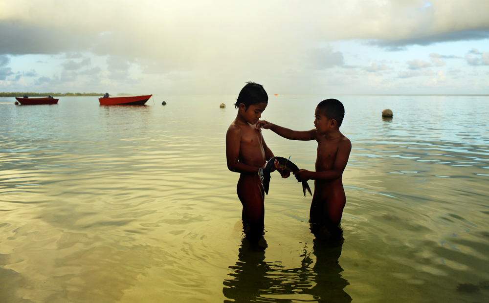 Children dine on raw fish in Funafuti, Tuvalu.