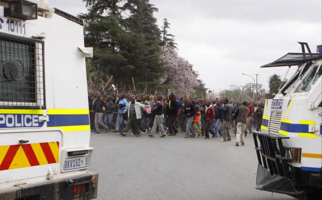 Police try to prevent striking mine workers from marching to the Karee shaft at the Lonmin Platinum Mine near Rustenburg on Wednesday. Photo: AP