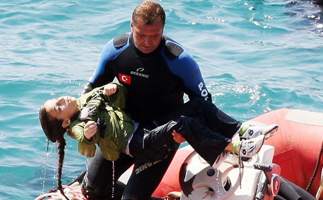A diver carries a young girl after a boat carrying illegal immigrants trying to reach Europe capsized in waters off western Turkey. Photo: EPA