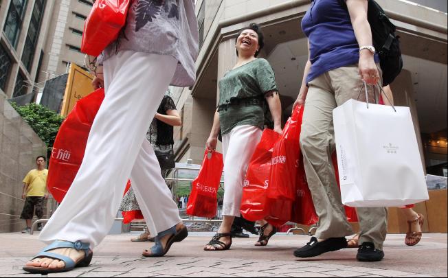 Mainland tourists carry bags full of goods during a buying spree in Causeway Bay, a popular shopping area for visitors. Photo: KY Cheng