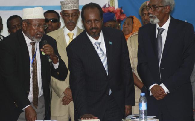 Flanked by the Speaker of Parliament Mohamed Osman Jawari (R) and the Supreme Court chief Aidid Ilka Hanaf (L), the newly elected President of Somalia Hassan Sheikh Mohamud (C) looks on as he is sworn in on Monday. Photo: EPA