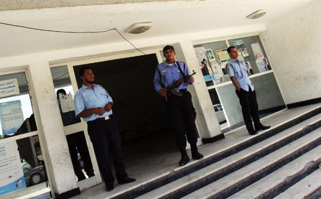 Libyan security men stand at the entrance of a police station on Thursday in Benghazi. Photo: AFP