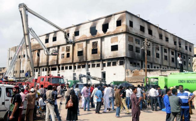 Pakistani rescue workers gather inside a garment factory following a fire in southern Pakistani port city of Karachi on Thursday. Photo: Xinhua 