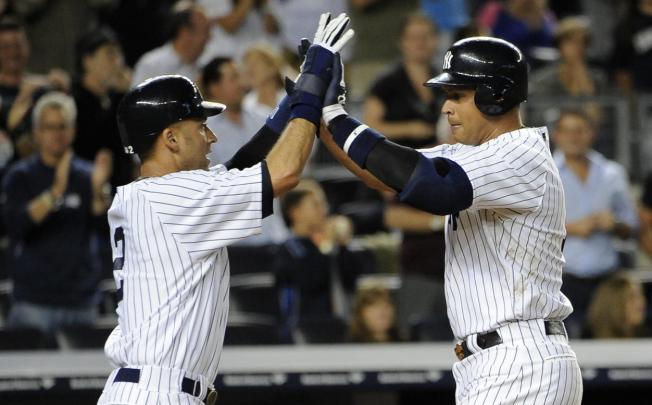 Derek Jeter greets Alex Rodriguez at home plate. Photo: AP