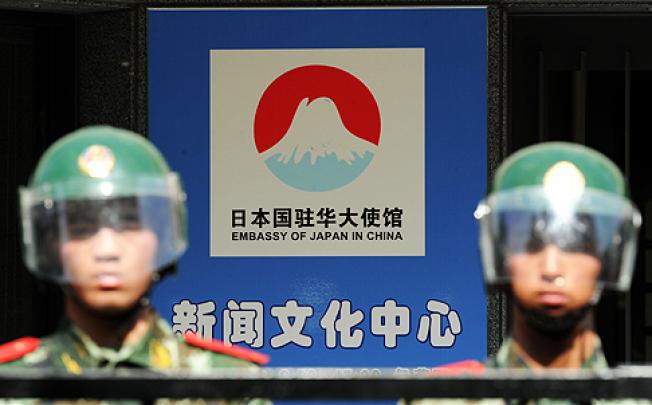 Beijing riot police stand guard the Japanese embassy on Sunday as protesters rally outside after Tokyo announced it had bought the Diaoyu islands. Photo: AFP