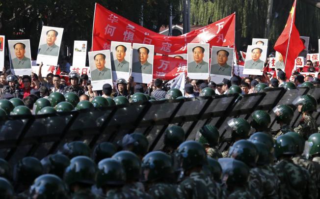 Rows of soldiers stand guard as protesters with portraits of Mao Zedong gather at the Japanese embassy in Beijing. Photo: Reuters