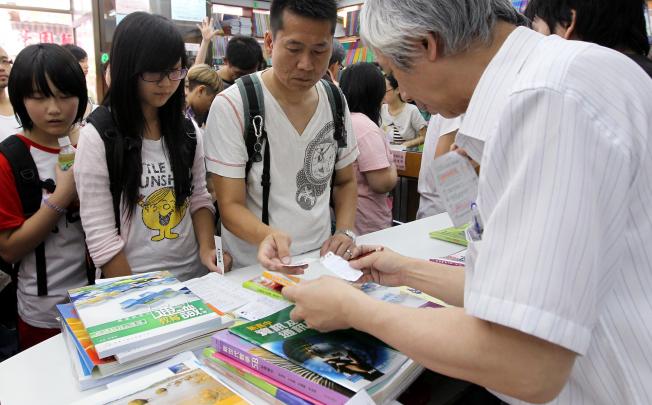 Students and parents check the cost of buying secondary school textbooks at a shop in Mong Kok. Secondary school book prices have gone up on average by 2.5 per cent.Photo: Dickson Lee