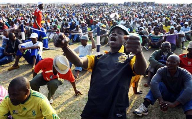 A miner from the Lonmin platinum mine celebrates after the striking workers and mine management came to an agreement on a wage increase six weeks after their illegal strike started in Marikana, South Africa, on Wednesday. Photo: EPA