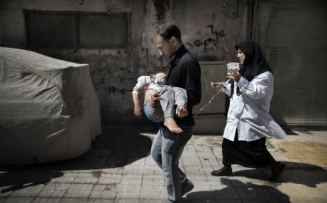 A Syrian man carries his wounded daughter outside a hospital in the northern city of Aleppo on Tuesday. Fierce clashes have broken out between Syrian rebels and regime forces. Photo: AFP 