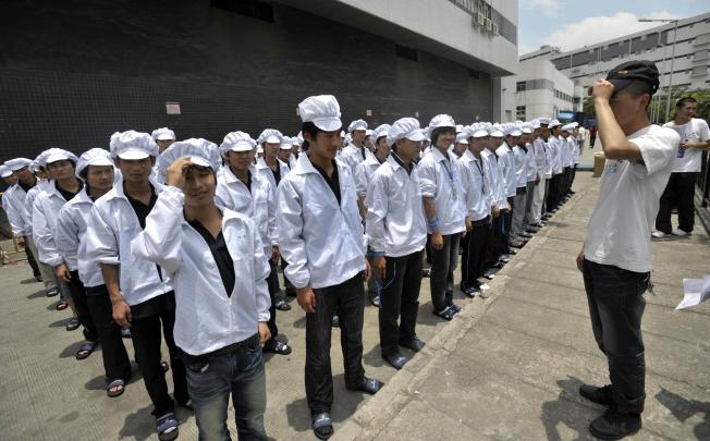 Foxconn workers outside a plant in Shenzhen in southern China’s Guangdong province before their shift. Photo: AFP