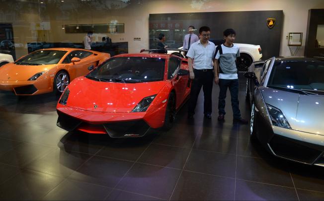 Chinese men look at luxury European sports cars at a showroom in Beijing on September 4, 2012.  Photo: AFP