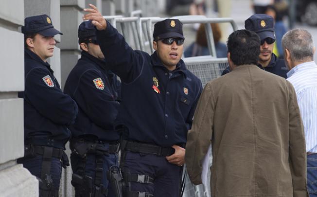 Police guarding the entrance of the Spanish parliament stop people entering the street in Madrid, on Tuesday. Photo: AP