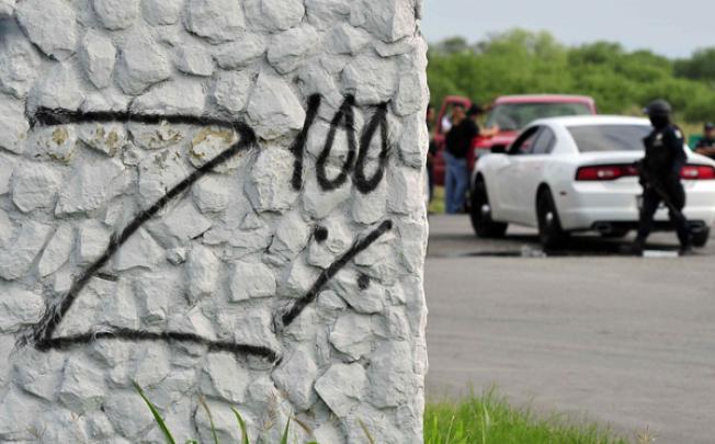A 'Z' spray painted on the welcome arch over the highway into San Juan appears to claim bodies found there in May as the work of the Zetas cartel. Photo: EPA