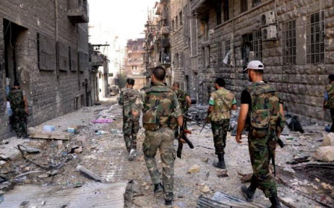 Syrian army soldiers patrolling in the street in Al-Arqoub area in Aleppo. Fighting raged in Aleppo on Saturday. Photo: EPA