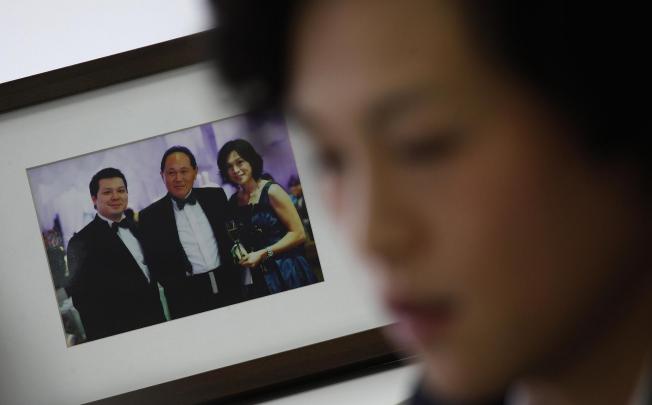 Gigi Chao, daughter of Hong Kong property tycoon Cecil Chao Sze-tsung, speaks next to a family photo of herself, her father (centre) and brother Howard. Photo: Reuters