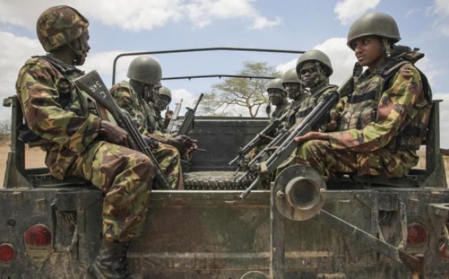 Kenyan soldiers serving with the African Union Mission in Somalia (Amisom) sit on the back of a military vehicle in southern Somalia on Sunday. Photo: AP