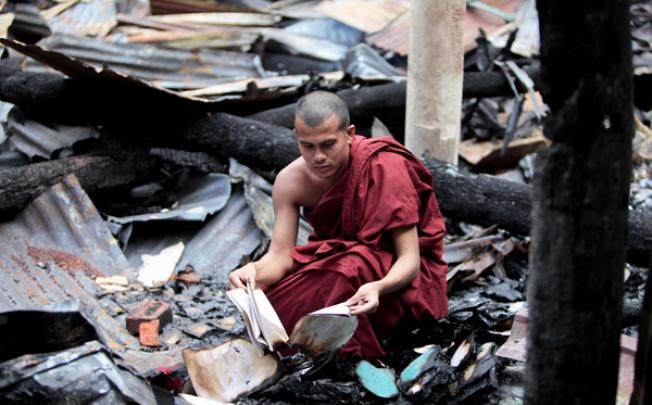 A Bangladeshi Buddhist monk checks the remains of burned religious books at a Buddhist temple that was torched in the coastal district of Cox's Bazar. Photo: AP