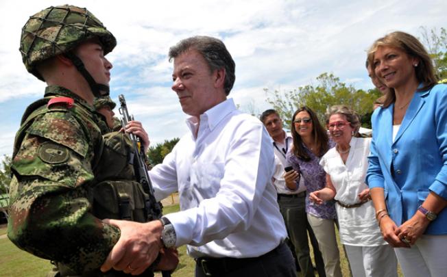 President Juan Manuel Santos (centre) greeting his son Esteban Santos during the delivery of weapons to new soldiers at the Tolemaida Army Base. Photo: AFP