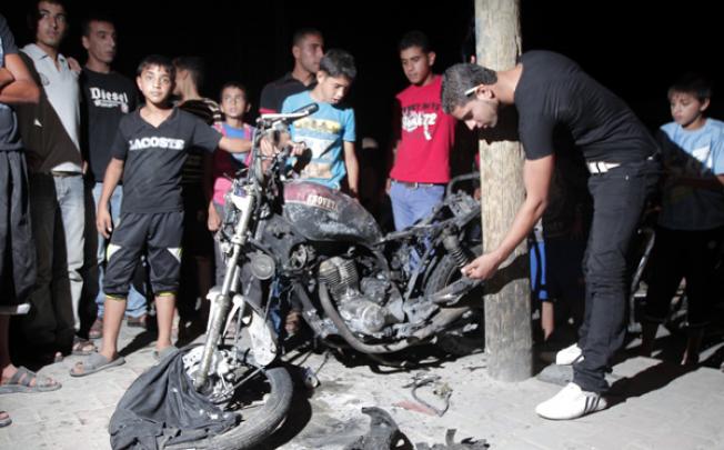 Palestinians inspect a destroyed motorbike following an Israeli aerial bombing in the southern Gaza Strip city of Rafa on Sunday. Photo: Xinhua