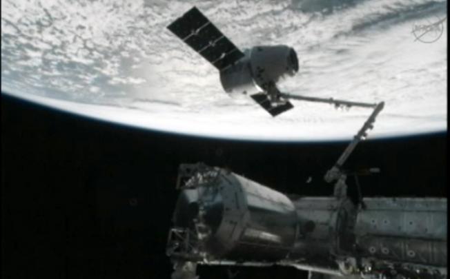 This image from NASA-TV shows the capture of the Dragon capsule by a robot arm on the International Space Station as they passed over the South Atlantic Ocean early on Wednesday. Photo: AP