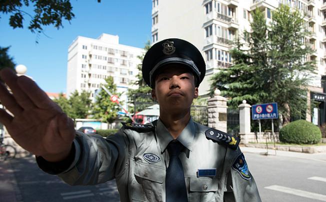A security guard prevents a photographer from taking photos outside Liu Xiaobo's apartment in Beijing on Wednesday. Photo: AP