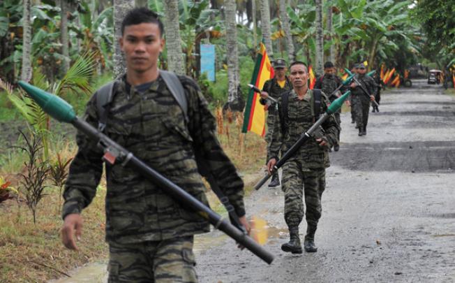 MILF rebels carrying rocket propelled grenades patrol inside their base at Camp Darapan, Sultan Kudarat province, Mindanao. Photo: AFP
