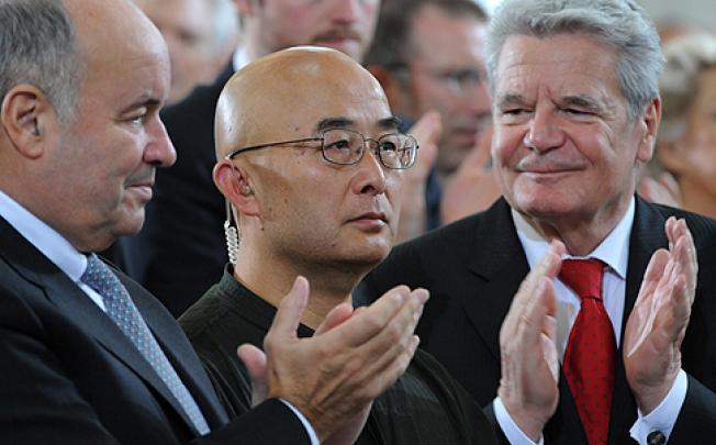 Liao Yiwu (centre) collects the German Book Trade Peace Prize in Frankfurt on Sunday. Photo: EPA
