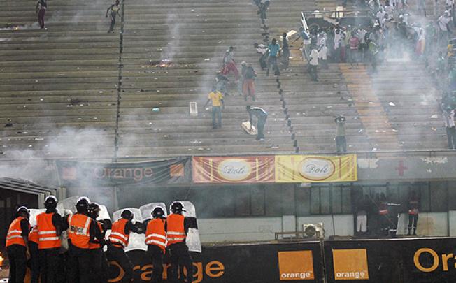 Senegalese riot police escort Ivory Coast players off the picth after a riot breaks out on Saturday. Photo: EPA