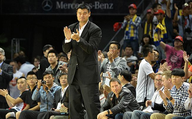 Retired NBA star Yao Ming watches the Clippers-Heat exhibition game from the sidelines on Sunday in Shanghai. Photo: AFP
