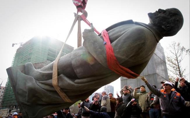 A crowd watches Lenin's statue being taken away. Photo AFP