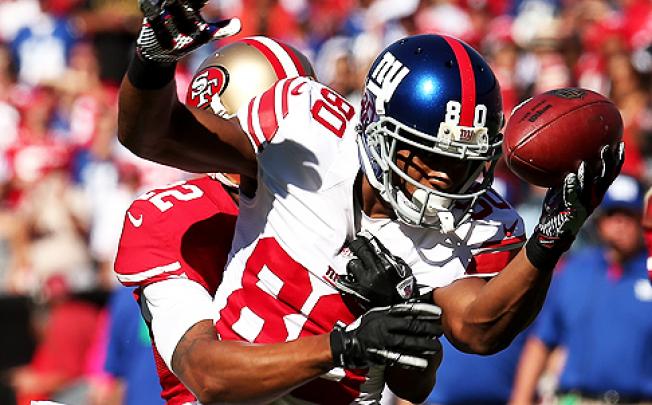 Wide receiver Victor Cruz of the New York Giants bobbles a pass against Carlos Rogers of the 49ers on Sunday. Photo: AFP