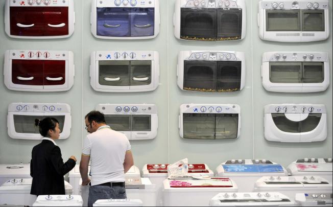 A buyer talks to a washing machine exhibitor at the Canton Fair yesterday. Activity was down due to global economic problems and a China-Japan territorial row. Photo: Xinhua