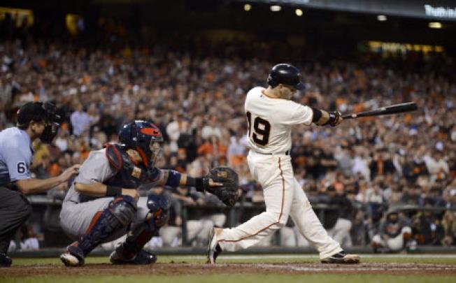San Francisco Giants second baseman Marco Scutaro (right) hits a single with the bases loaded as St. Louis Cardinals catcher Yadier Molina looks on. Photo: EPA