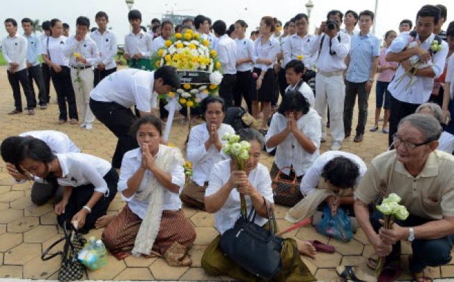 Cambodian people pray for the late former King Norodom Sihanouk in front of the Royal Palace in Phnom Penh on Tuesday. Photo: AFP