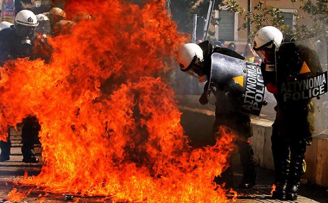 Riot police are engulfed in flames by a Molotov cocktail bomb thrown by protesters in Athens. Photo: EPA 