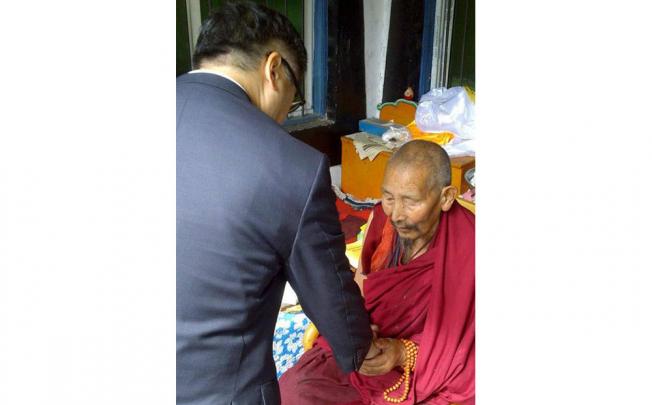 US envoy Gary Locke shakes hands with a Tibetan monk.