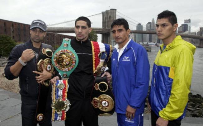 Boxer Danny Garcia, second left, from Philadelphia, the current Ring Magazine, WBC and WBA Super Lightweight Champion, wears his belts, as he poses for photos with opponent Erik Morales, of Tijuana, Mexico, third left, near the Brooklyn Bridge, in the Brooklyn borough of New York. Photo: AP
