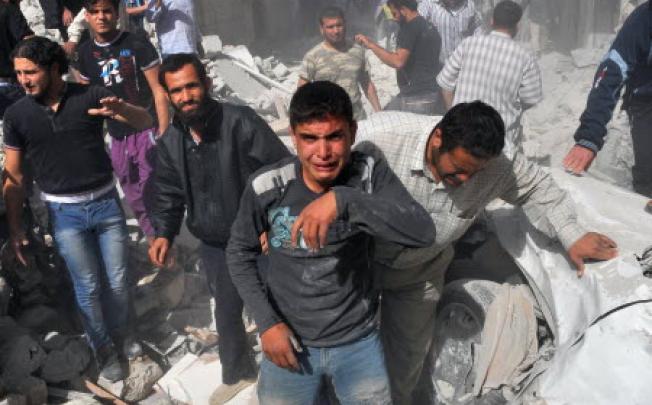 Syrian men react following an airstrike by Syrian government forces in Maaret al-Numaan on Thursday. Photo: AFP
