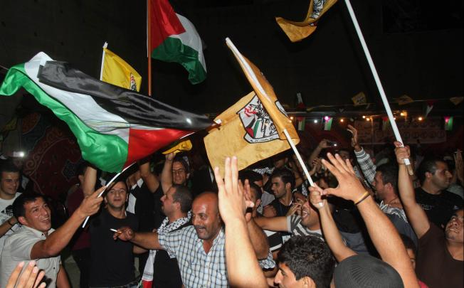 Palestinian Fatah supporters wave Fatah and national flags as they celebrate in the West Bank city of Bethlehem. Photo: AFP
