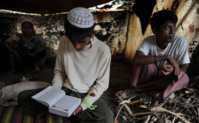 Rohin Mullah reads the Koran in his tent at the Dabang camp, set up for people displaced by the sectarian unrest. Photos: AFP